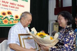 第五郡郡委书记黄玉女芳红向华人革命老前辈孙盛强颁发55年党龄纪念章。