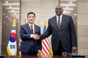 11月13日，在首尔国防部大楼举行的第55次韩美安保会议（SCM）上，韩国国防部长官申源湜（左）和美国国防部长劳埃德·奥斯汀签署“2023韩美定制型威慑战略”（TDS）文件后合影留念。（图：韩联社）