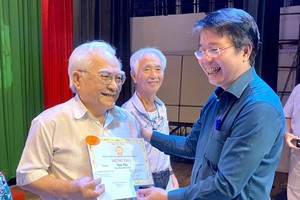 第六郡人委会副主席黎清平向两位85岁华人教师陈标（左一）和黄金城（左二）祝寿。