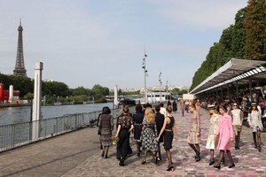7月4日，在法国巴黎塞纳河边，模特展示法国品牌香奈儿2023/2024秋冬高级定制新品。（图：新华社）