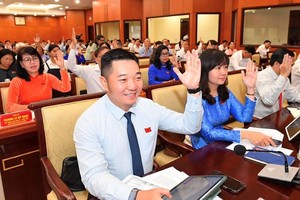 图为市人民议会第十二次会议代表举手表决通过《决议》。（图：越勇）