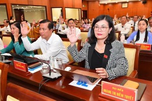 图为市人民议会第十二次会议代表举手表决通过《决议》。（图：越勇）