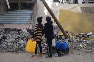 在加沙汗尤尼斯，孩子们在街头寻找饮用水。（图：联合国）