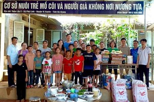 杨显单位正抚养三十名儿童和照顾两位孤寡长者。阮文面老师站在左一。