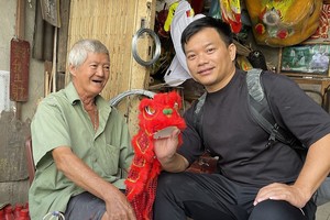 湛德兴（左）向笔者赠送他精心扎作的舞狮纪念品。