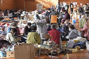 图为石川县穴水町的疏散点内取暖的灾民。（图：共同社）