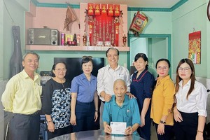 第十一郡慰问团向高龄模范老人许庭雄赠送岁暮礼物。