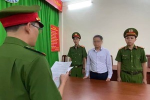 执法警员向嫌犯阮武海（白衣）宣读逮捕令。（图：警方提供）