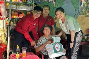 温陵会馆常值副理事长吴丽株（右）和第五郡红十字会代表问候孤寡长者。