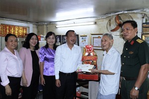 市人民议会副主席范成坚（左四）向华人老党员刘天云赠送贺年礼物。