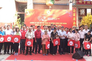 市委民运处、市红十字会领导和各会馆、企业代表与贫困者合影。