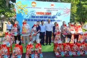 第五郡越南祖国阵线委员会领导和名誉会长赵骞赠礼物给华人贫困者。