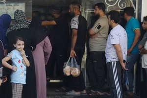 人们在加沙的一家面包店外排队。（图: UNICEF）