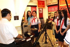 第一郡阮攸初中学校学生聆听关于西贡-嘉定别动博物实物意义的介绍。