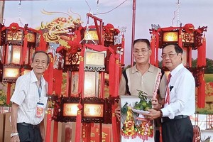 平阳省土龙木市天后宫王永胜理事长（左）、副理事长陈永安（右）向安强木器公司移交圣灯。
