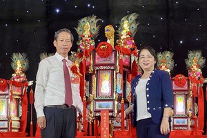 市越南祖国阵线委员会主席陈金燕向义安会馆常值副理事长陈振炎移交“天地父母财灯”。