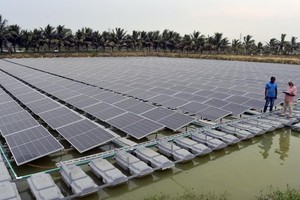 2023年6月5日，在孟加拉国查帕伊诺瓦布甘杰，工作人员检查水上漂浮太阳能光伏发电站运行情况。（图：新华社）