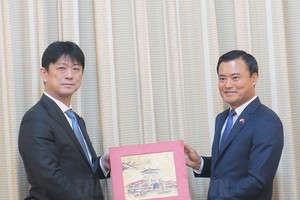 市人委会副主席裴春强（右）向日本外务省副大臣高村正宏赠送对外交往纪念品。（图：市党部新闻网）