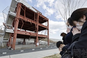 东日本大地震迎来13週年，人们在地震发生时刻朝着宫城县南三陆町的防灾对策大楼遗迹默哀。摄于3月11日下午2点46分。（图：共同社）