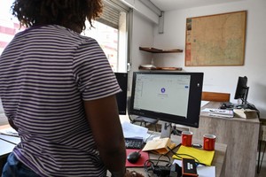 3月15日，在科特迪瓦阿比让，一名女子站在断网的电脑前。（图：新华社）