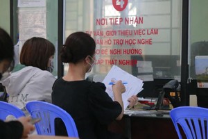 民众等待办理获享失业津贴的手续。