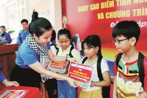 本市共青团向同塔省新鸿县葛更中小学校的家境清寒学生赠送医保卡。