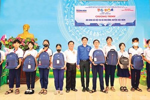 陈必盛(图中，青衣者)在福门县二平乡赠送清贫学生礼物。（图：市党部新闻网）