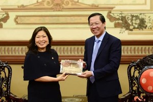 市人委会主席潘文迈（右）向加拿大出口促进、国际贸易与经济发展部长伍凤仪赠送对外交往纪念品。（图：光定）