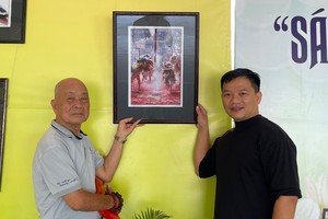 周经春（左）向笔者赠送《瑞狮迎春》作品。