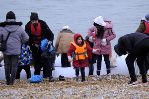 移民乘船抵达英国邓杰内斯角海岸。（图：新华社）