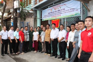 第十一郡第十一坊领导和庆云南院住持周华邦向吴晋弟华人贫困户移交修缮“温情屋”工程。