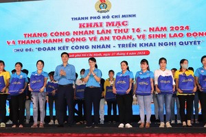 越南劳动总联团副主席午维晓与市劳动联团主席陈氏妙翠向贫困会员赠送礼物。（图：蔡芳）