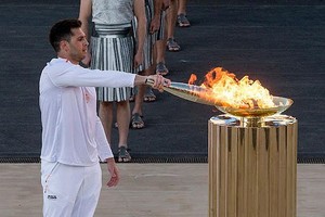 4月26日，最后一棒火炬手、希腊国家水球队队长冯图利斯点燃圣火盆。（图：新华社）