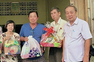 市华人抗战俱乐部主任孙盛强（右）向会员赠送礼物。