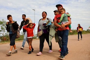 一个家庭徒步穿越委内瑞拉边境后抵达巴西。（图：国际移民组织）