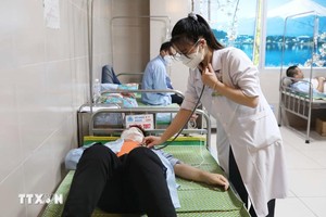 医生在给一名疑似食物中毒的大学生查体。（图：越通社）