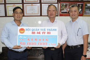 穗城会馆理事长卢耀南和理事梁锦权向本报编委文忠孝移交5000万元赠报经费。