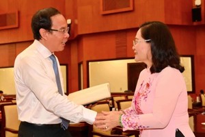 市委书记阮文年与市人民议会主席阮氏丽在会议间隙交谈。（图：越勇）