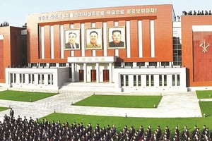 朝鲜党校革命事迹馆外墙悬挂着金氏三代领导人的肖像。（图：互联网）