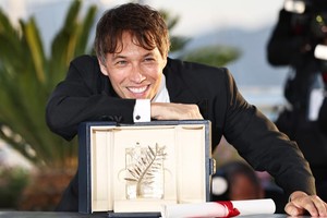 5月25日，在法国南部城市戛纳举行的第77届戛纳电影节上，美国导演肖恩·贝克与“金棕榈奖”奖杯合影留念。（图：新华社）