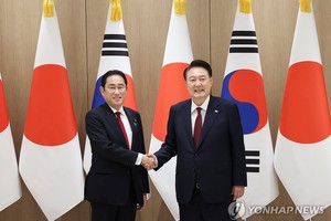 5月26日，在首尔龙山总统府，韩国总统尹锡悦（右）与日本首相岸田文雄握手合影。（图：韩联社）