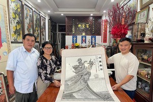 郑钊城与姚金鸾夫妇（左一、二）把《海国安澜》作品交予笔者。