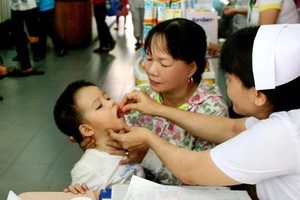 医护人员在给一名小孩补充维生素A滴剂。（图：成山）