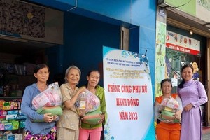 谢大娘（左二）赠送礼物给贫困户。