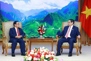 政府总理范明政与老挝中央检查委员会主任、国家监察总署长坎潘‧蓬马塔交谈。（图：越通社）