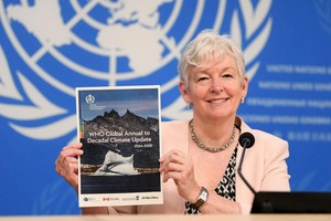 6月5日，世界气象组织副秘书长科·巴雷特在瑞士日内瓦展示《全球年际至十年际气候最近通报（2024-2028）》的报告。（图：新华社）