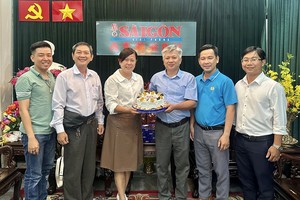 第六郡红十字会主席黎氏宝庄（左三）与代表图向本报编委黎曰孟雄（左四）赠送蛋糕祝贺。