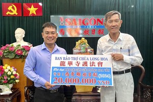 龙华寺护法会副会长陈健安（右）向本报编委文忠孝转交2000万元。