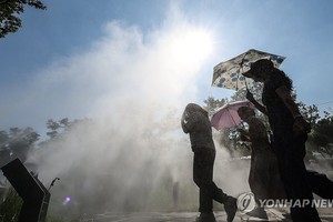 6月18日，在大邱市，市民打着阳伞出行。（图：韩联社）