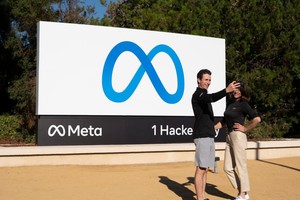 图为 2021年10月28日，在美国旧金山湾区，人们在“元”标志牌前留影。（图：新华社）